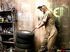 This lovely shemale is hard at work in the garage fixing tires dressed in her jumpsuit and h...