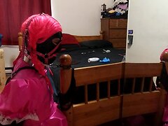 A fine young crossdresser is bound and collared to the bedpost in a strict armbinder, with s...