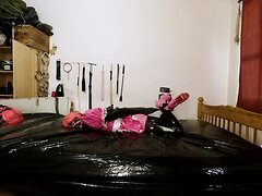 A submissive crossdresser maid is tightly bound in an armbinder and gagged, wearing a steel ...